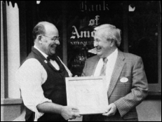Marketing Executive Vice President Jack Lindquist presents a framed pair of Disney Dollars to Silhouette Cutter Harry Brice
