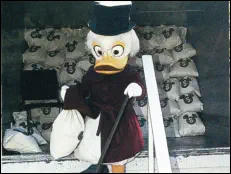 Scrooge McDuck, the 'Treasurer,' delivers the first shipment of Disney Dollars from an armored truck.