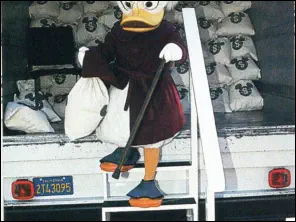 Scrooge McDuck, the 'Treasurer,' delivers the first shipment of Disney Dollars from an armored truck.